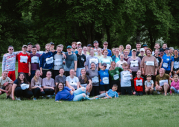 Etwa 50 Läuferinnen und Läufer unterschiedlichen Alters stehen erschöpft, aber glücklich vom Spendenlauf auf einer Wiese im Liebenzeller Kurpark. Für ein Gruppenfoto haben sie sich versammelt. Die Gruppe lächelt in die Kamera – dankbar und stolz, den Lauf erfolgreich geschafft zu haben.