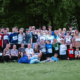 Etwa 50 Läuferinnen und Läufer unterschiedlichen Alters stehen erschöpft, aber glücklich vom Spendenlauf auf einer Wiese im Liebenzeller Kurpark. Für ein Gruppenfoto haben sie sich versammelt. Die Gruppe lächelt in die Kamera – dankbar und stolz, den Lauf erfolgreich geschafft zu haben.