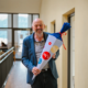 Rektor Volker Gäckle steht lächelnd mit einer Schultüte im Hochschulgebäude